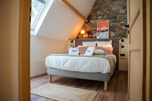 a bedroom with a bed with a stone wall at Les Granges du Hautacam in Artalens-Souin