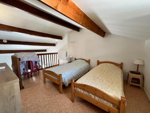 deux lits dans une chambre avec plafonds en bois dans l'établissement Belle villa climatisée 4-5 couchages 2 terrasses piscine commune parking dans résidence sécurisée 200m de la mer LRMA45, à Portiragnes