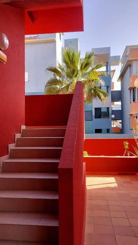 a red wall with stairs in front of a building at RdG Home in Puertito de Güímar
