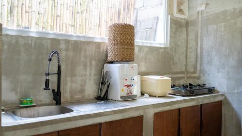 a kitchen counter with a sink and a microwave at Villa Rosa Siargao in General Luna