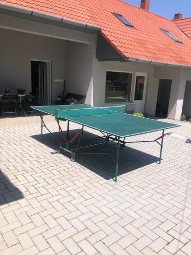 a ping pong table in front of a house at Villa Rondine Vendégház Tilaj in Tilajújhegy