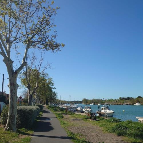 a walking path next to a river with boats at Studio Agde 5 min from the sea in Agde