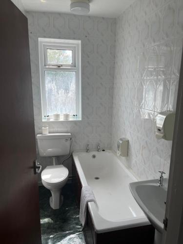 a bathroom with a toilet and a tub and a sink at Moorville Hall Hotel in Stoke on Trent