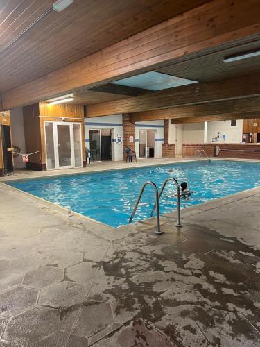 a large swimming pool with blue water in a building at Moorville Hall Hotel in Stoke on Trent