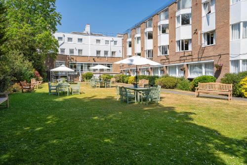 a park with tables and chairs and a building at The Clarendon Hotel in London