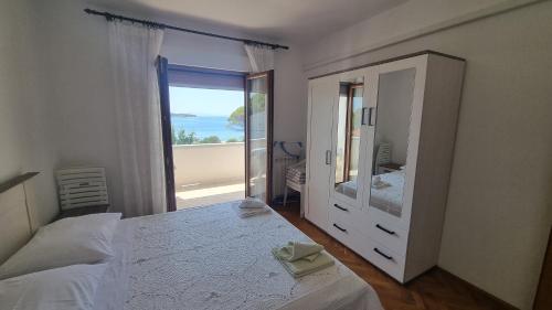 a bedroom with a large mirror and a large window at Apartments DEXI in Banjol