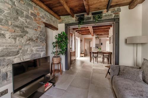 a living room with a stone wall at Ama'Ca Dulza - by MyHomeInComo in Laglio