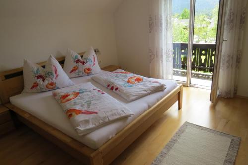 a bed with pillows on it in a room with a window at Ferienhaus Anke - Ausseerland Salzkammergut in Pichl bei Aussee