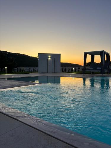 a swimming pool with the sunset in the background at Dani's residence in Supersano