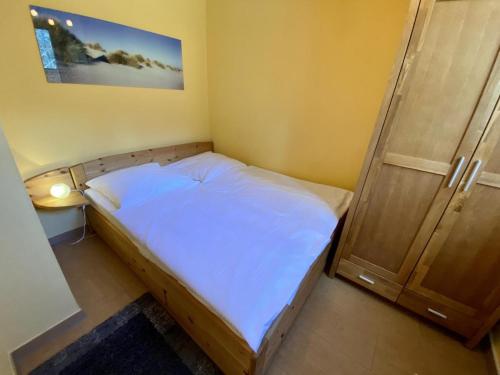 a small bedroom with a bed and a door at Ferienhaus Ostseeperle in Warnemünde