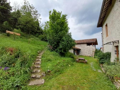un jardin avec un banc et un bâtiment dans l'établissement Apt 1er étage - Gite aux 1000 chemins, à Saint-Joseph-de-Rivière