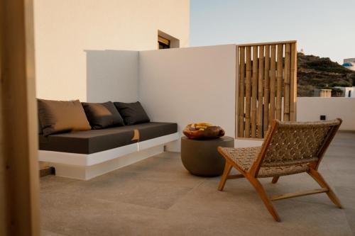 a living room with a couch and a chair at Sohoro Olive in Ios Chora