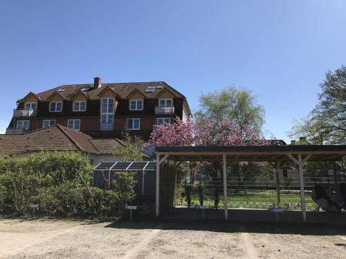 a building with a gate in front of a house at Landhaus Immenbarg, Wellness in Warnemünde