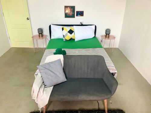 a bed in a room with a green blanket on it at 326 Podtel at The Breakie Bar in Bangkok