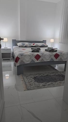 una camera da letto con un letto, un tappeto e due lampade di Bubi Apartment a Gevgelija