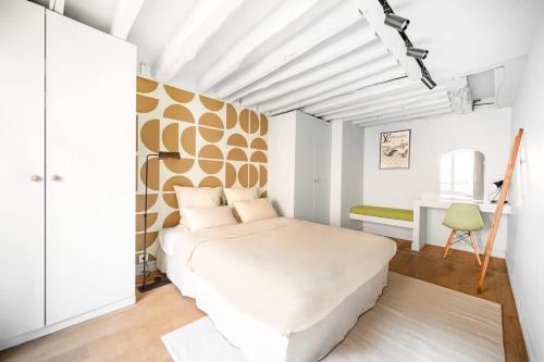 une chambre avec un grand lit blanc dans une pièce dans l'établissement Appartement design et confortable au cœur du Marais, à Paris