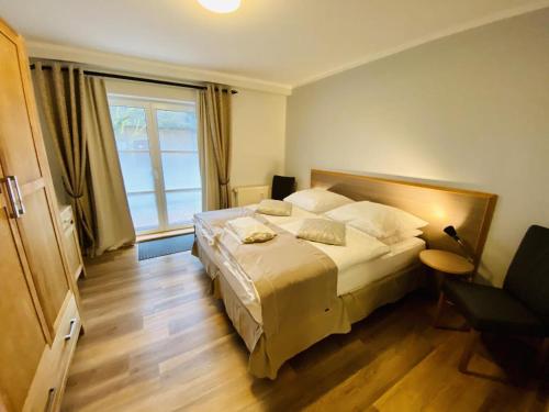 a bedroom with a bed and a large window at Landhaus Immenbarg, Sonne in Warnemünde