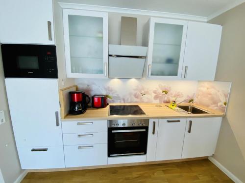 a kitchen with white cabinets and a sink at Residenz/Meeresrauschen in Warnemünde
