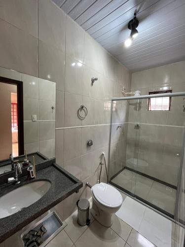 a bathroom with a shower and a toilet and a sink at Cantim d' Casa in Catas Altas