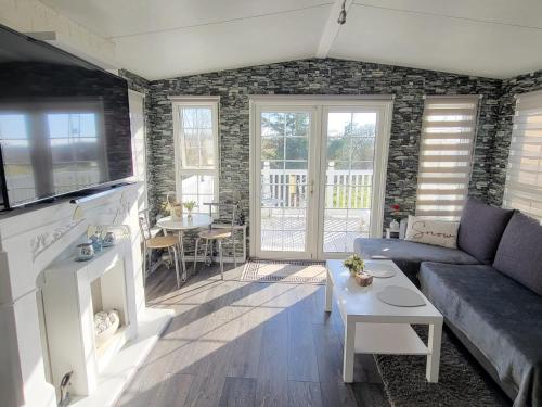 un soggiorno con un divano e un tavolo di Sunny corner caravan a Saint Osyth