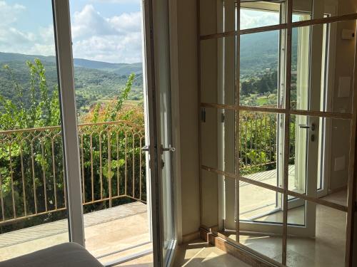 a room with a balcony with a view of the mountains at Relais dei Molini - Villa dei Molini in Castagneto Carducci