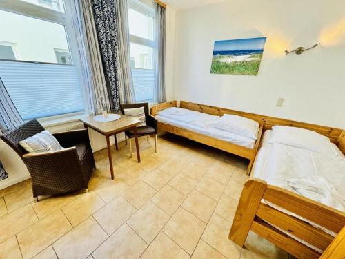 a bedroom with a bed and a desk and a table at Appartement Feuerdorn in Warnemünde