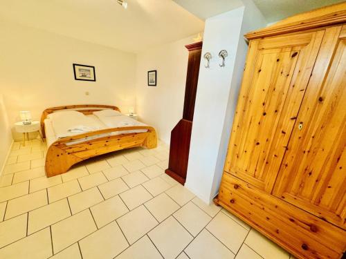 a bedroom with a bed and a wooden cabinet at Appartement Eibeneck in Warnemünde