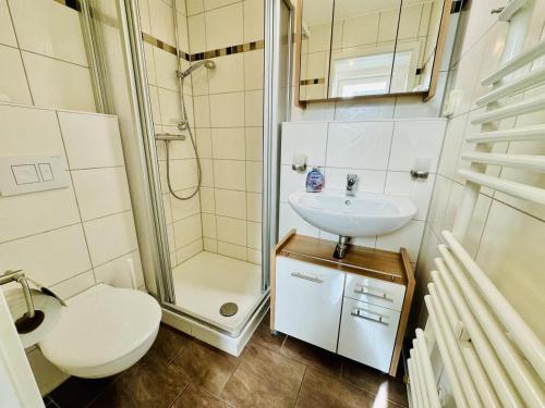 a bathroom with a toilet a sink and a shower at Appartement Eibeneck in Warnemünde