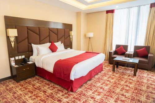 a hotel room with a large bed and a chair at Ramada by Wyndham Murree Lower Topa Resort in Murree