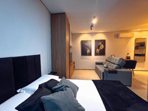 a hotel room with a bed and a couch at Apto/Flat Moderno Perto da Unifebe e shoppings in Brusque