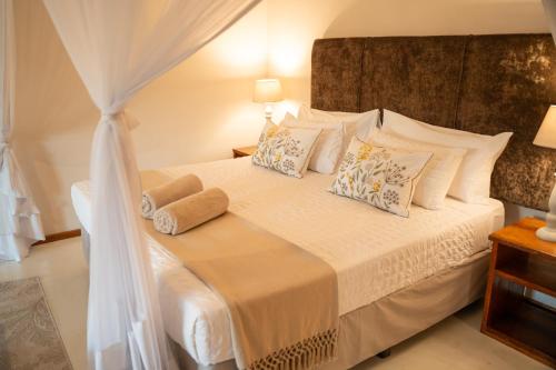 a bedroom with a white bed with pillows at Bela Flor Beach Front Apartments in Inhambane