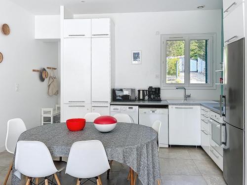 une cuisine avec une table et des placards blancs dans l'établissement Les Issambres, à Roquebrune-sur Argens