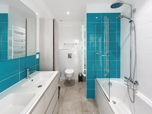 une salle de bain avec une baignoire, un lavabo et des toilettes dans l'établissement Les Issambres, à Roquebrune-sur Argens