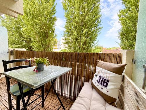 a small patio with a table and a couch at L'Estival, Royan in Royan