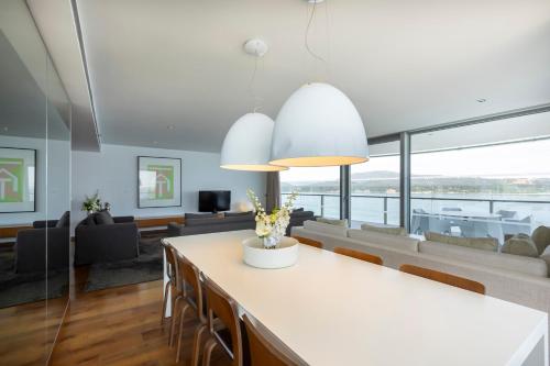 a kitchen and living room with a table and chairs at Troia Design Hotel in Troia