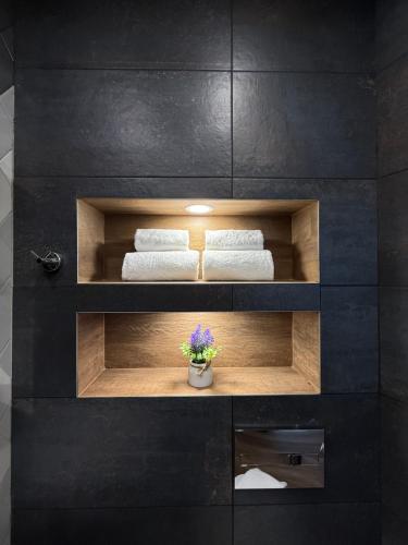 un bagno nero con due asciugamani e una pianta di Gorna Banya luxury apartments a Sofia