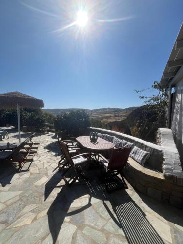 a table and chairs on a patio with the sun at Casa Paros in Parikia