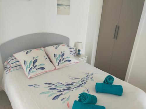 - un lit blanc avec des fleurs bleues au-dessus dans l'établissement Apt T3, 2ch, tout à pied, 50m plage, Pointe du Bec, à Pornichet