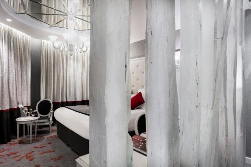 a bedroom with a white bed and a pillar at Maison Albar - Le Diamond in Paris