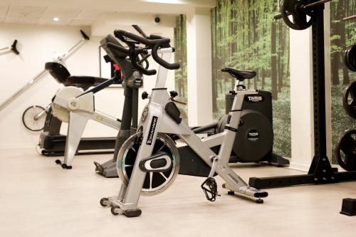 a gym with three exercise bikes in a room at Best Western Plus Hotel Eyde in Herning