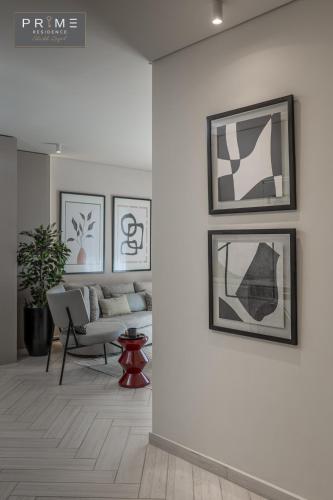 a living room with a couch and pictures on the wall at Prime Residence Sheikh Zayed in Sheikh Zayed