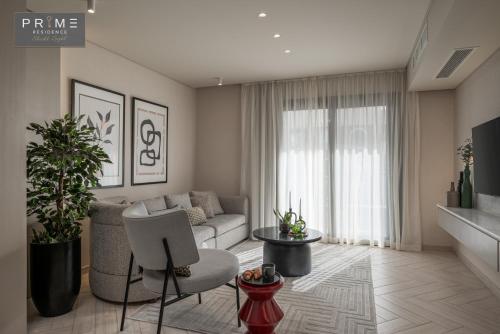 a living room with a couch and a chair at Prime Residence Sheikh Zayed in Sheikh Zayed
