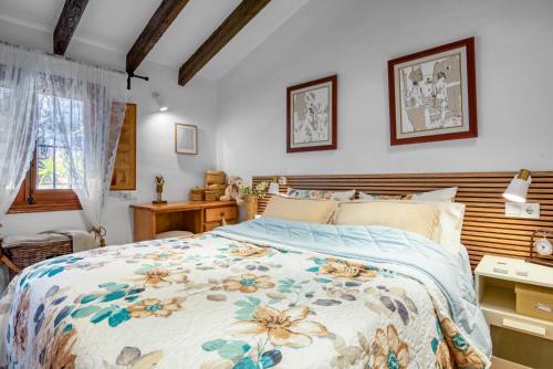 a bedroom with a bed with a floral bedspread at Casa Trinidad in Denia