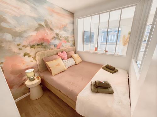 une petite chambre avec un lit et une fenêtre dans l'établissement Charmant Appartement au Cœur de Deauville avec Balcon et plage à 10 min à Pied, à Deauville