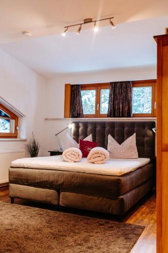 a bedroom with a large bed with a leather headboard at Silberleithen Estate in Biberwier