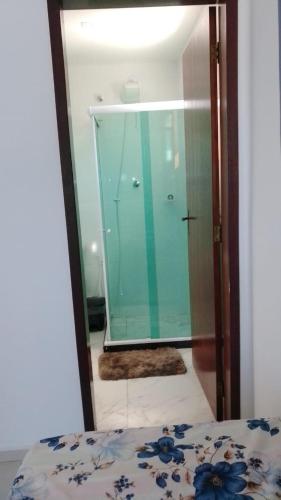 a bedroom with a glass door and a mirror at Araruama junto a Lagoa - Centro in Araruama