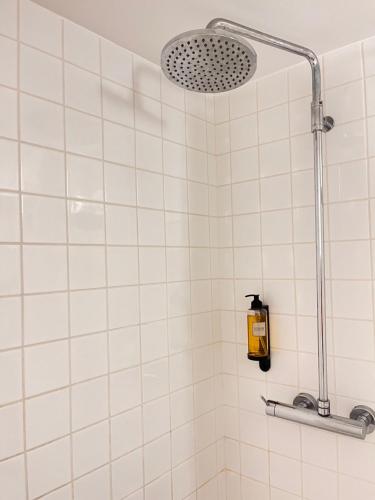 a shower in a bathroom with white tiles at Loureiro 59 in Coimbra