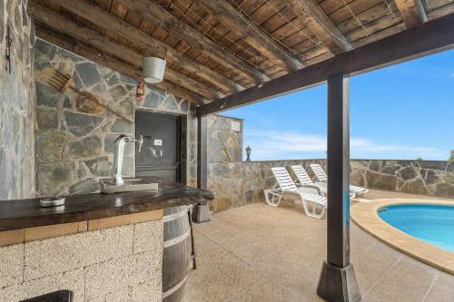a bathroom with a tub and a swimming pool at Casa Rural Tijoco in Adeje