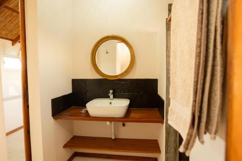 a bathroom with a sink and a mirror at Bela Flor Beach Front Apartments in Inhambane