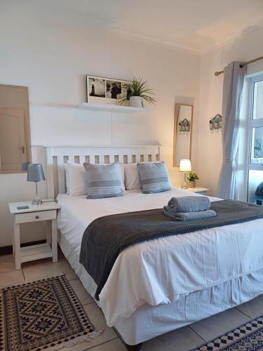 a bedroom with a large white bed and a window at Vista Bonita 29 in Mossel Bay